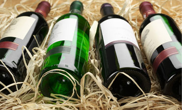 Four bottles of wine lying on straw